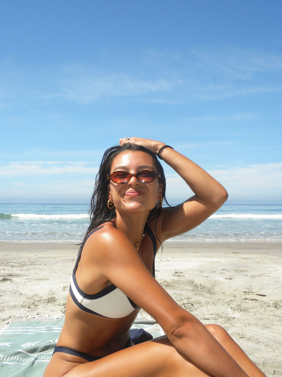 The coach is posing at the beach.